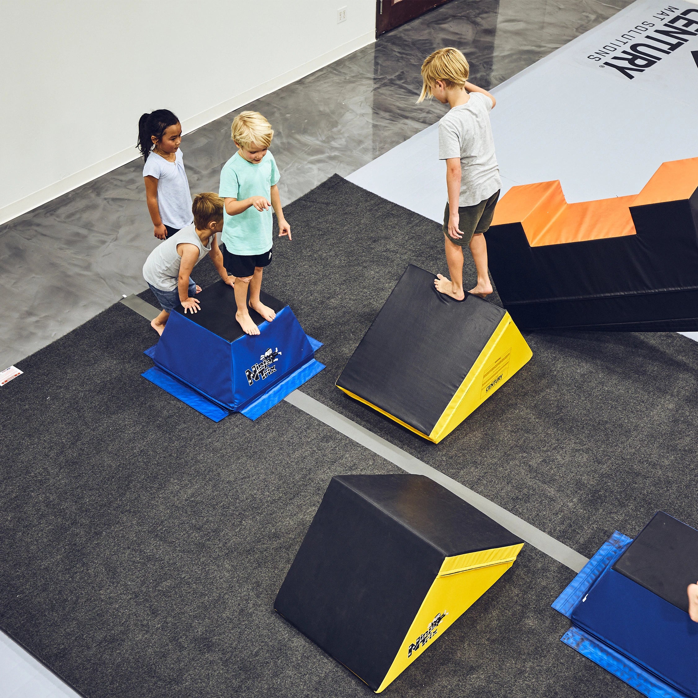 kids playing on ninja trix obstacle course in a martial arts class